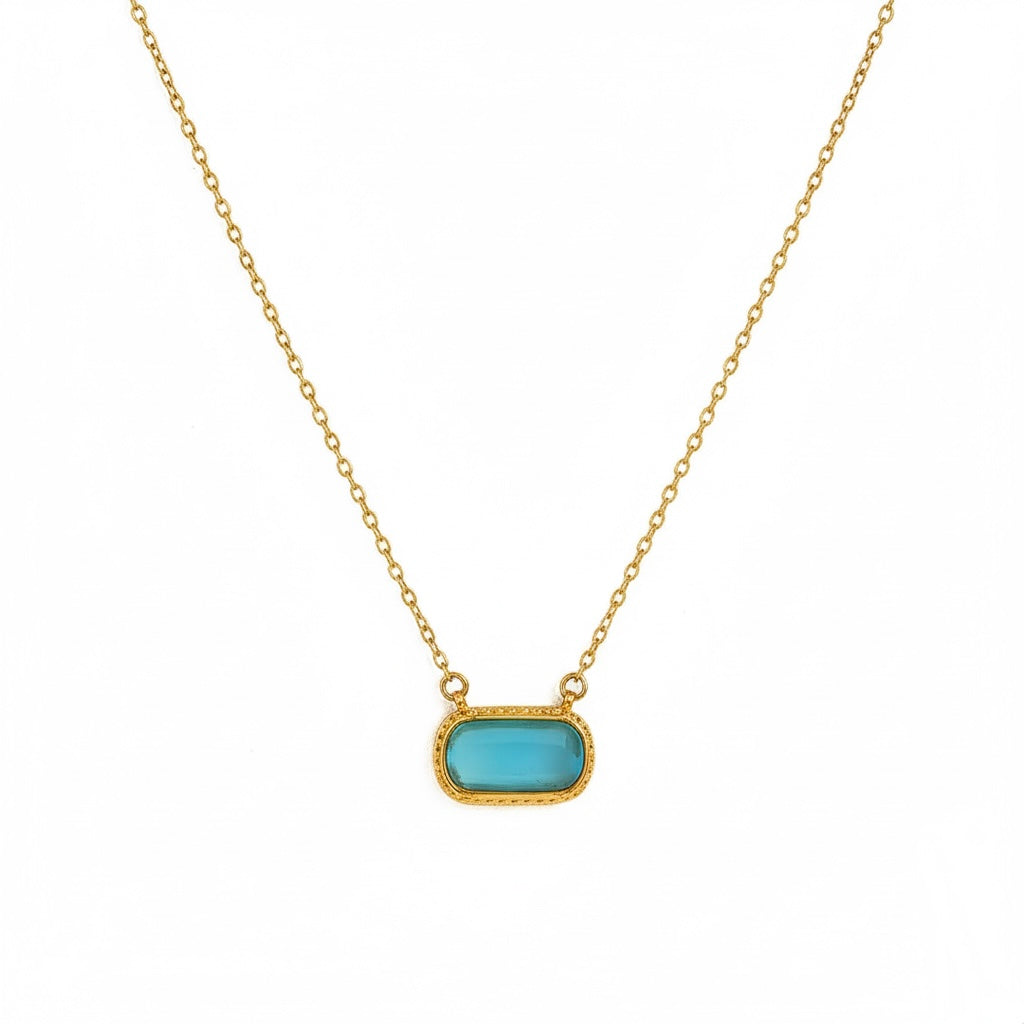 Necklace with a turquoise pendant on a gold chain against a white background