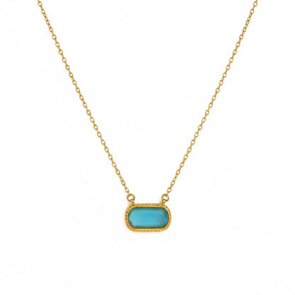 Necklace with a turquoise pendant on a gold chain against a white background