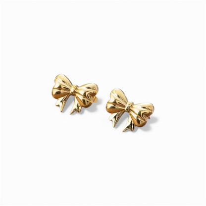 Gold bow-shaped earrings on a white background