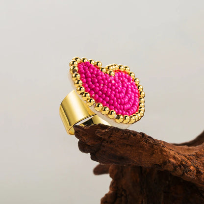 Gold ring with a pink bead heart