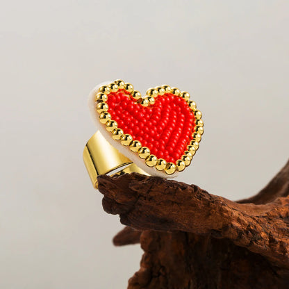 Heart-shaped ring with red center and gold border