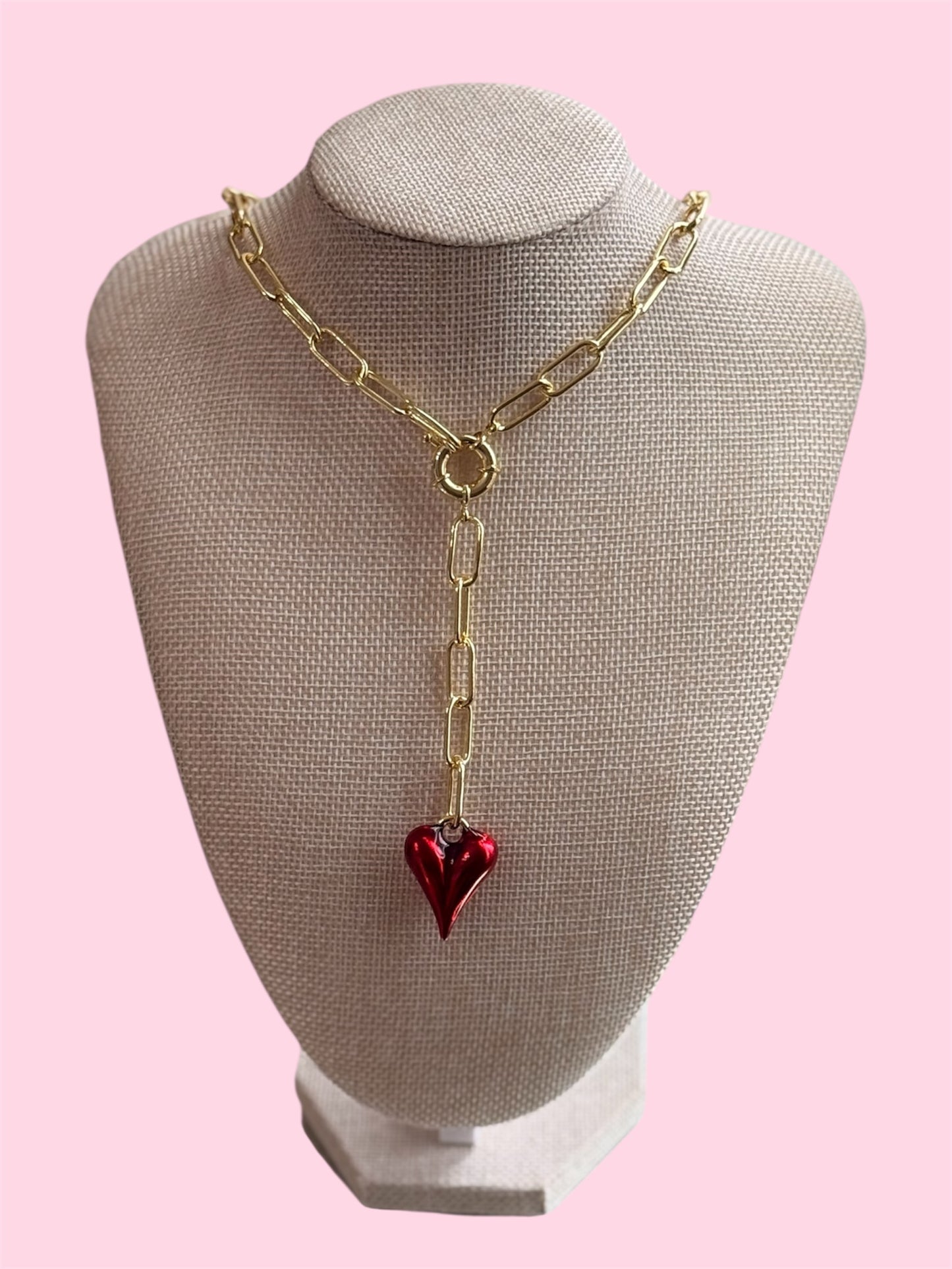 Gold necklace with a red heart pendant on a mannequin bus