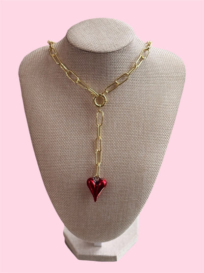 Gold necklace with a red heart pendant on a mannequin bus