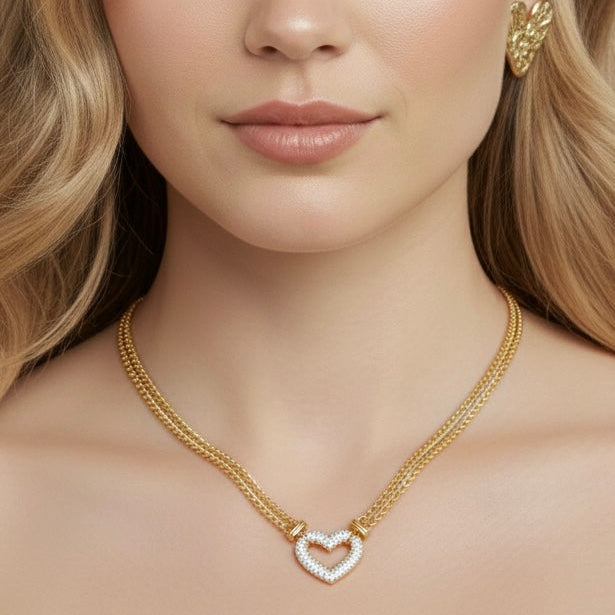 Woman wearing a gold necklace and earrings against a beige background