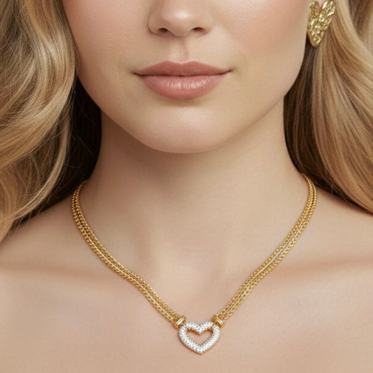 Woman wearing a gold necklace and earrings against a beige background