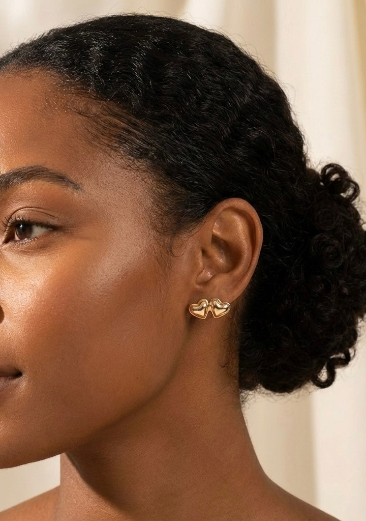 Close-up of a woman wearing gold earrings with a neutral background