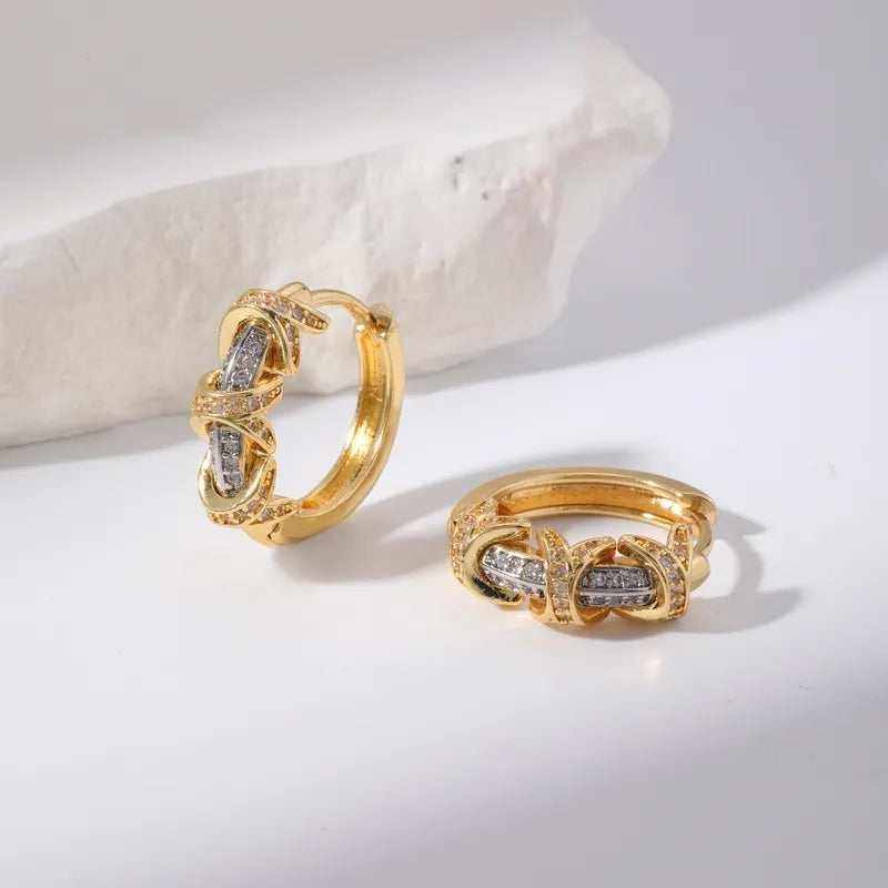 Gold hoop earrings with diamond accents on a light background