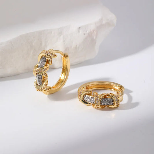 Gold hoop earrings with diamond accents on a light background
