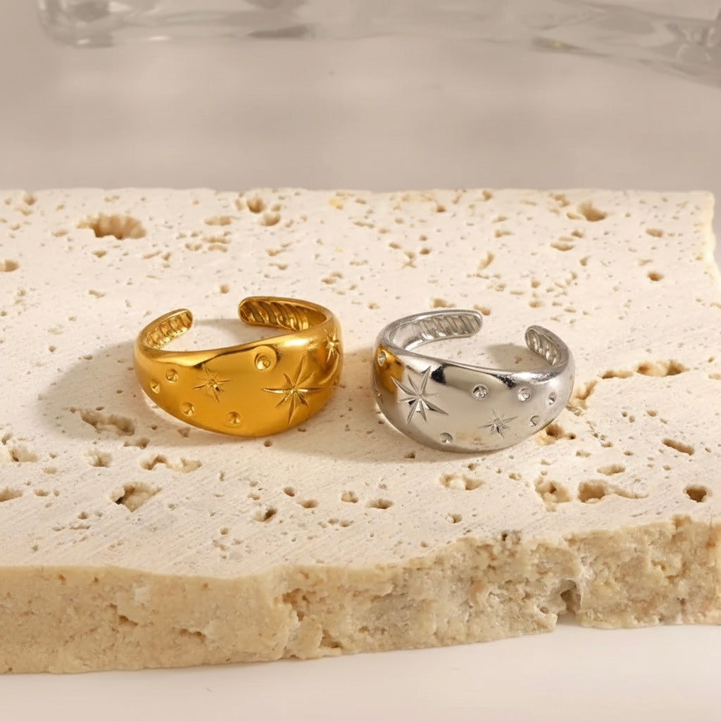 Gold and silver open-topped rings on a textured stone surface