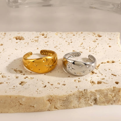 Gold and silver open-topped rings on a textured stone surface