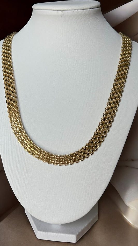 Gold chain necklace on a white mannequin bust