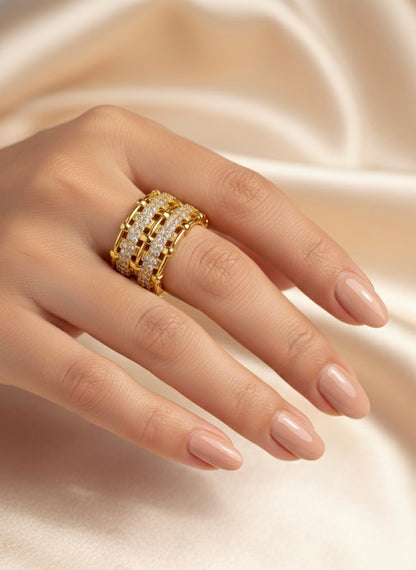 Gold ring with diamonds on a hand against a soft beige background