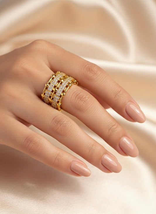 Gold ring with diamonds on a hand against a soft beige background