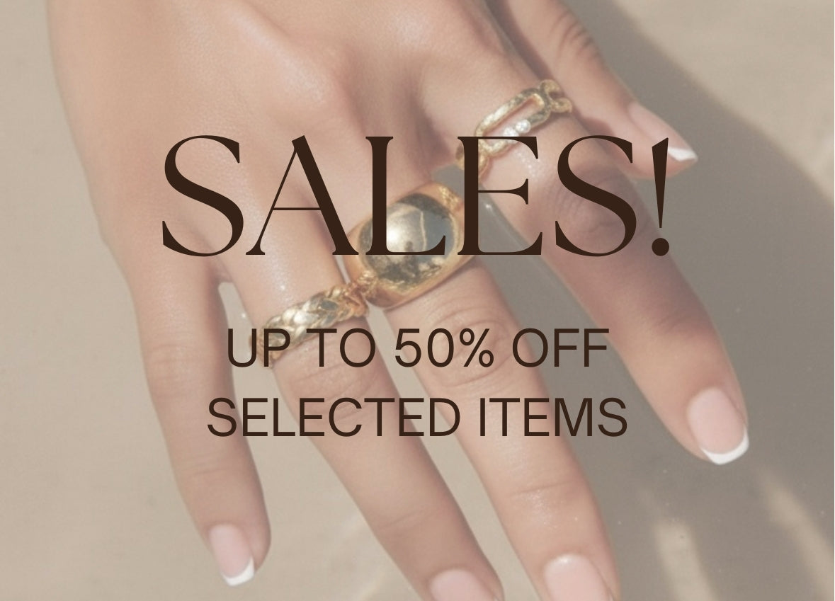 Hand wearing gold rings with 'SALES! UP TO 50% OFF SELECTED ITEMS' text overlay.