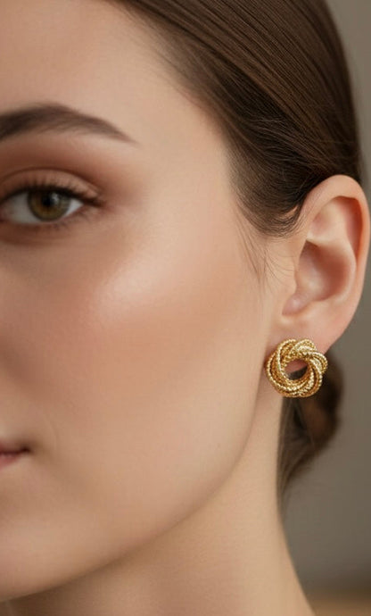 Close-up of a woman wearing gold earrings with a blurred background