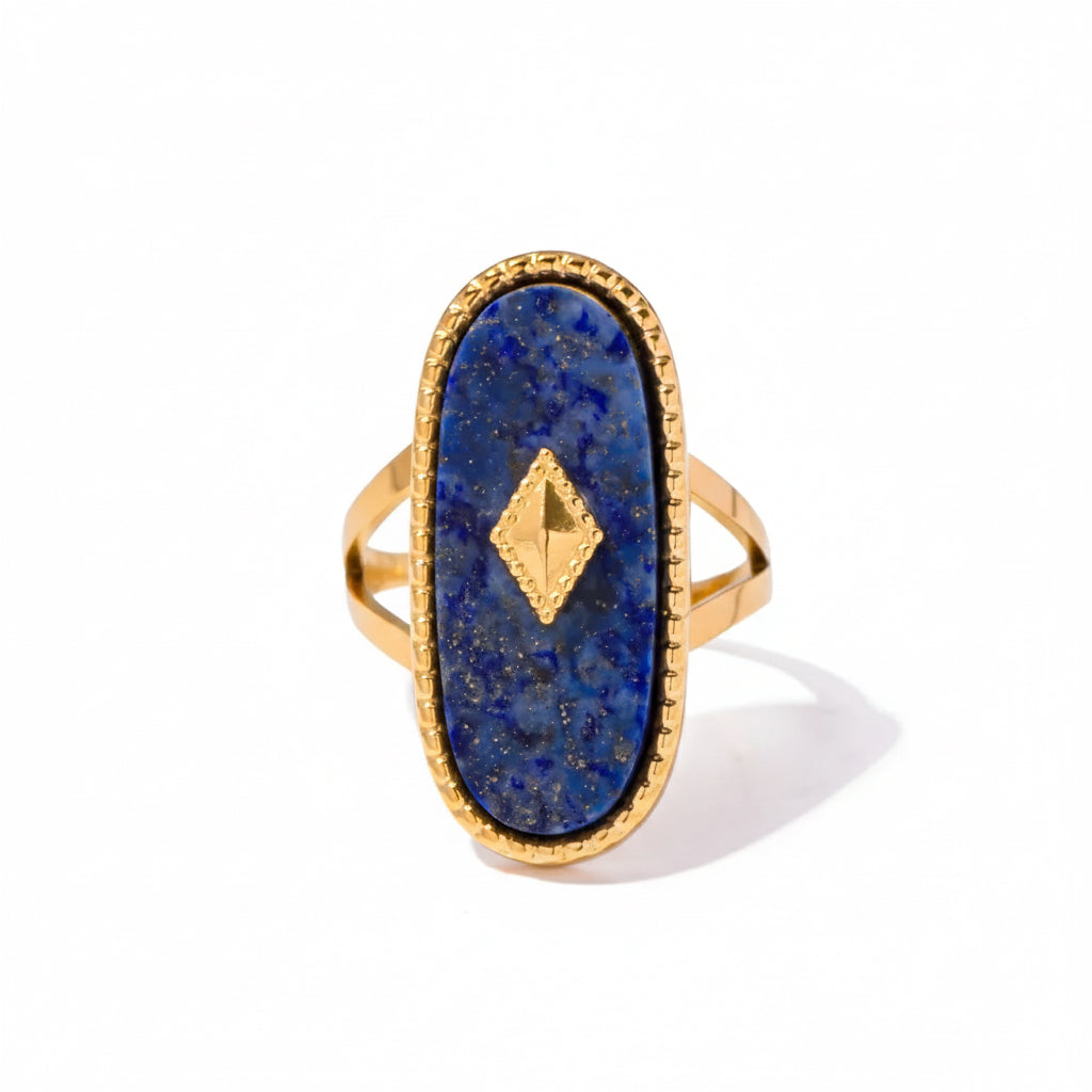 Gold ring with a blue stone and gold accent on a white background