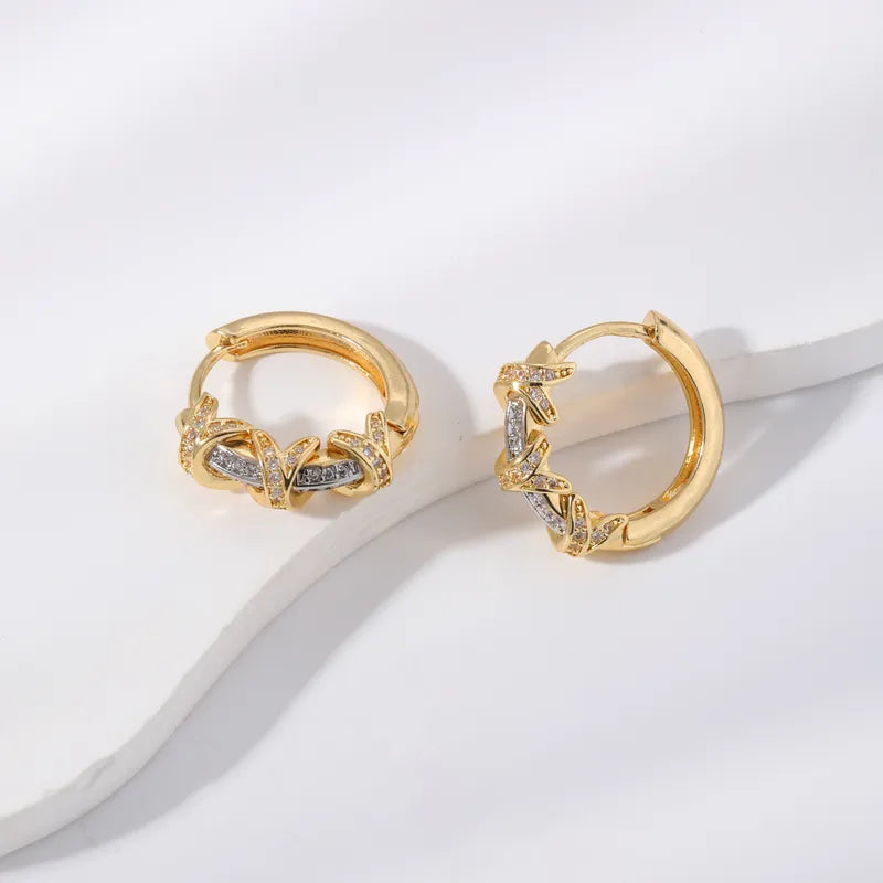 Pair of gold hoop earrings with diamond accents on a light background