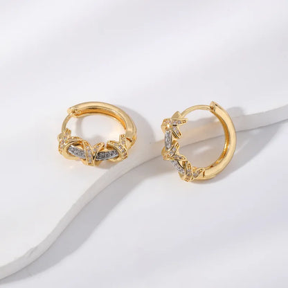 Pair of gold hoop earrings with diamond accents on a light background