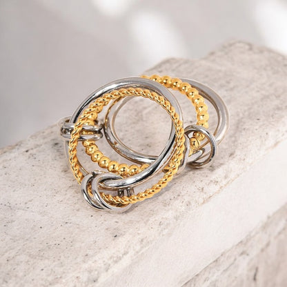 Three gold and silver rings stacked on a textured surface
