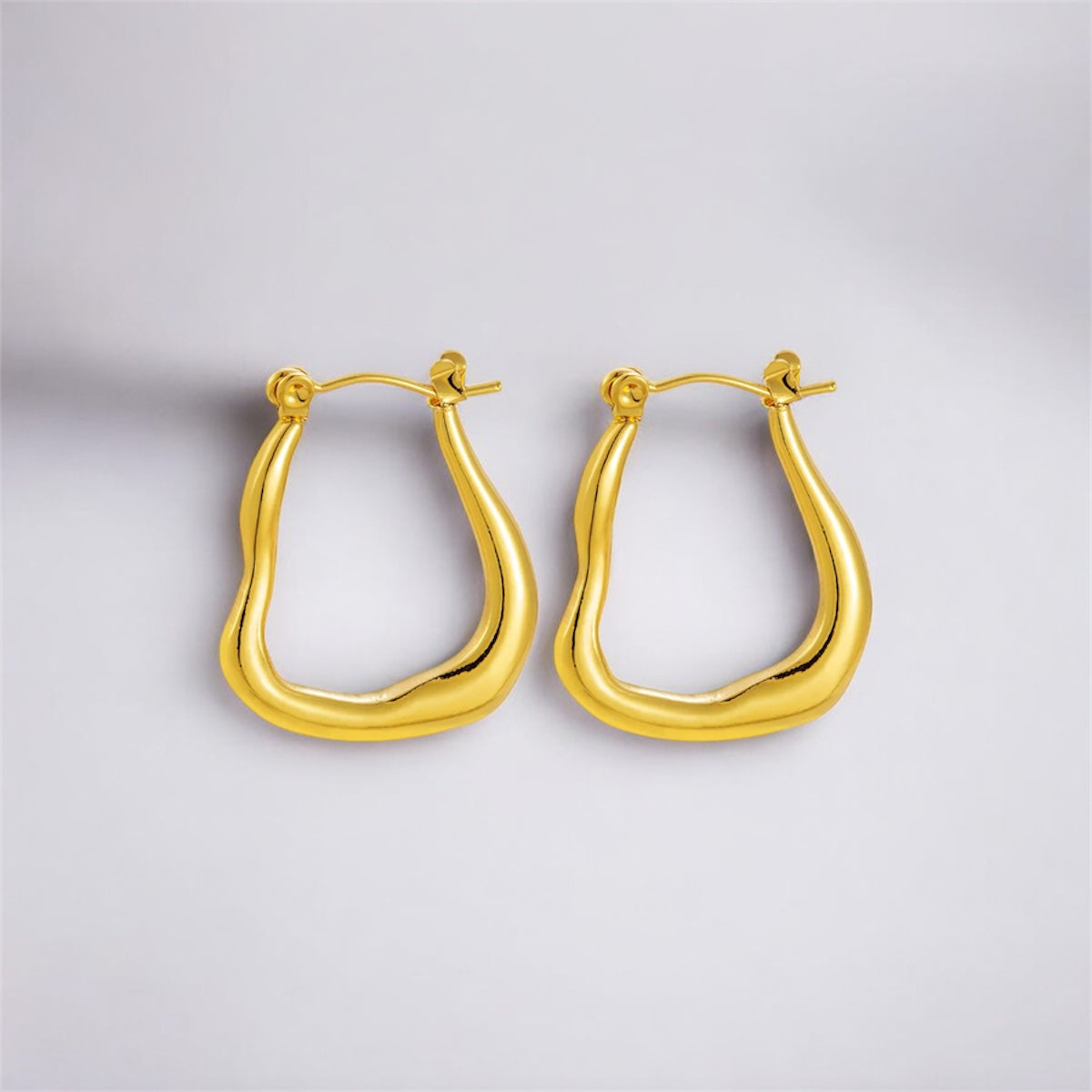 Gold hoop earrings on a light gray background