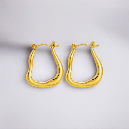 Gold hoop earrings on a light gray background